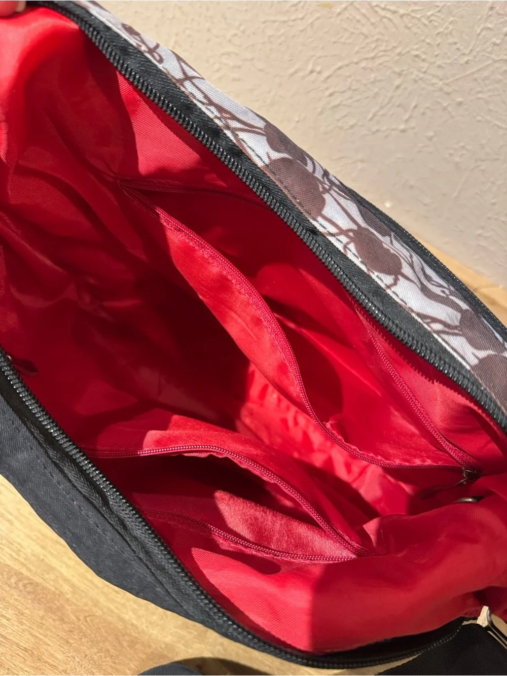 Satchelli Black Crossbody Bag with Floral Accent and Red Lining